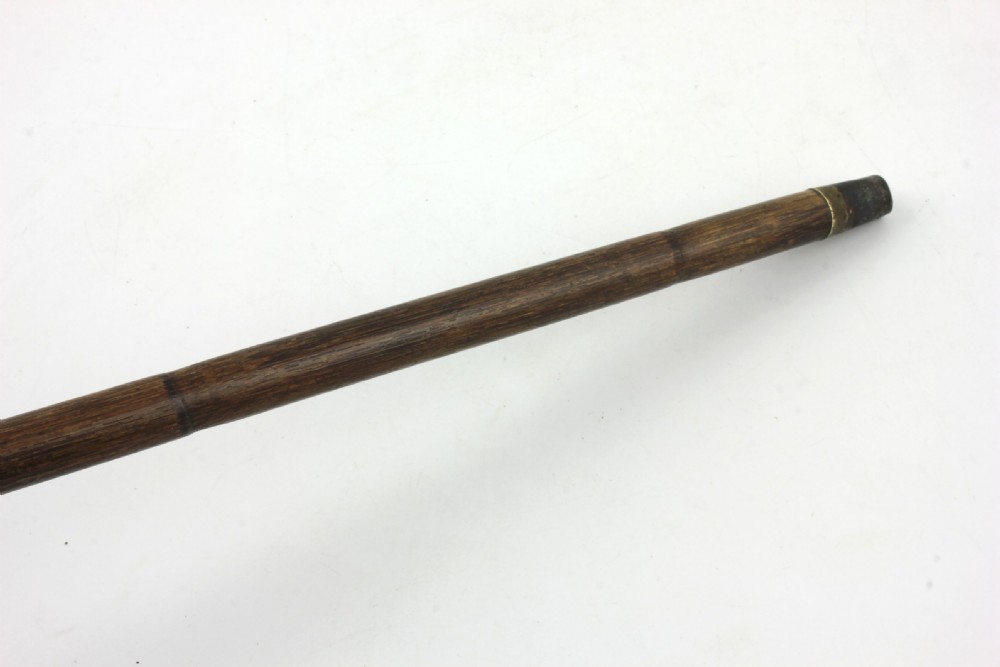 An Edwardian walking stick featuring a curved brown horn handle with a silver tip and an engraved sterling silver collar attached to a dark bamboo shaft. View XII