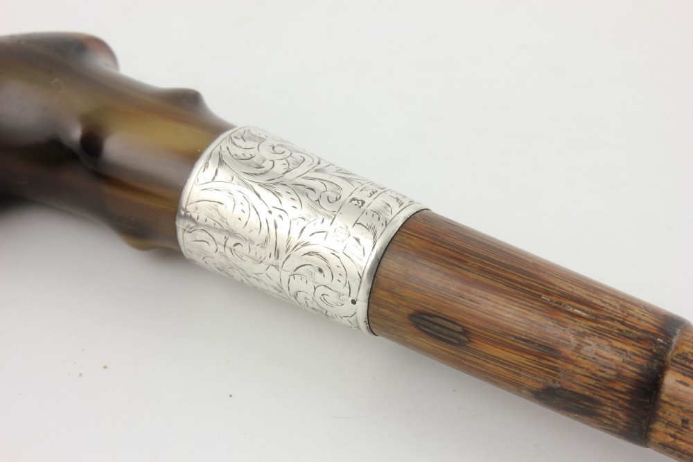An Edwardian walking stick featuring a curved brown horn handle with a silver tip and an engraved sterling silver collar attached to a dark bamboo shaft. View XIV