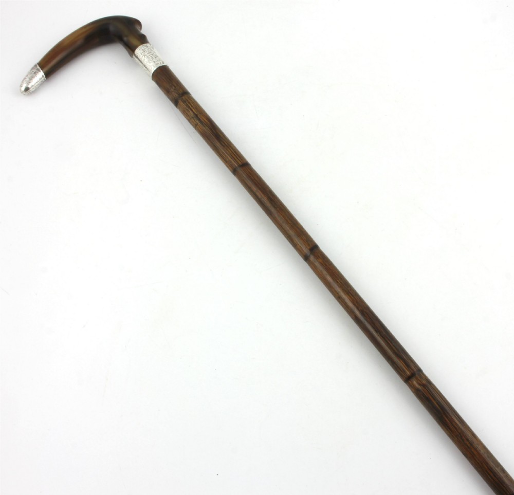 An Edwardian walking stick featuring a curved brown horn handle with a silver tip and an engraved sterling silver collar attached to a dark bamboo shaft. View XVII