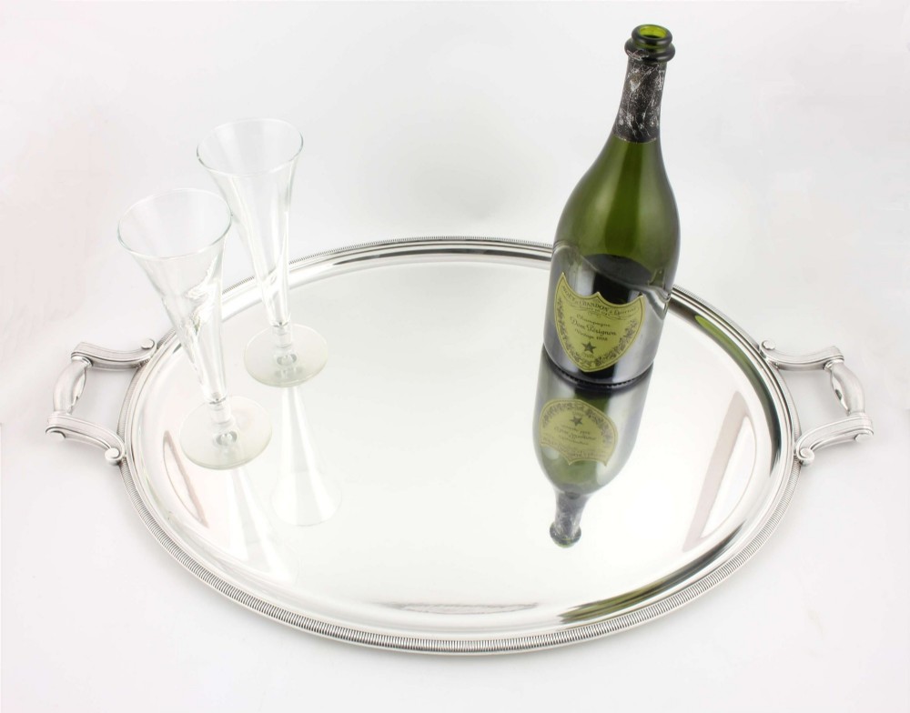 An extra large oval silver-plated tray with reeded border detail and two outer scroll handles on a plain background. View IV
