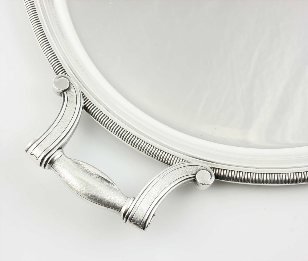 An extra large oval silver-plated tray with reeded border detail and two outer scroll handles on a plain background. View X