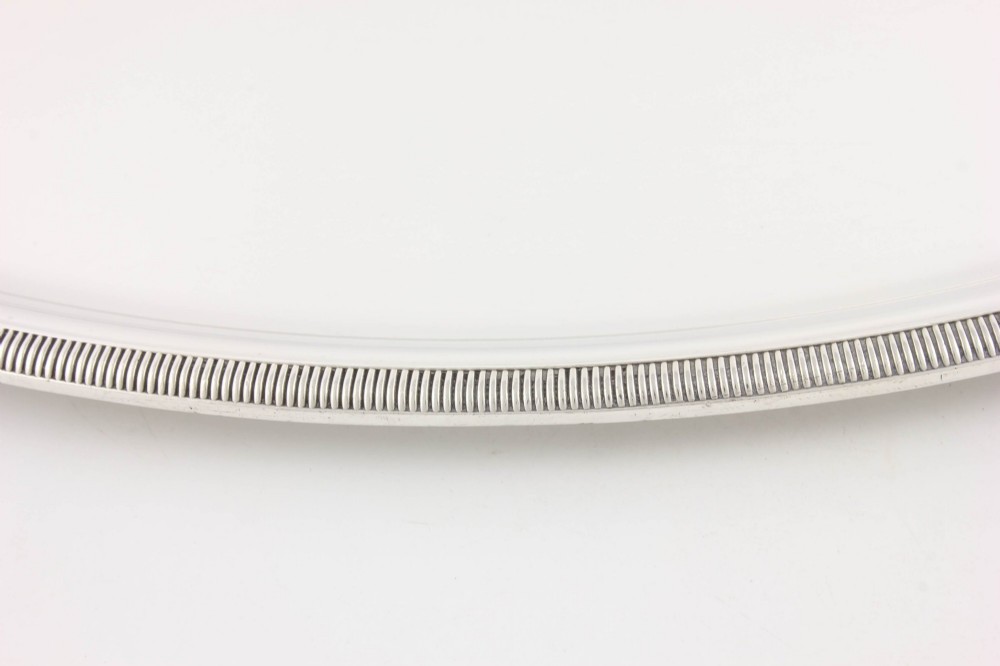 An extra large oval silver-plated tray with reeded border detail and two outer scroll handles on a plain background. View XI