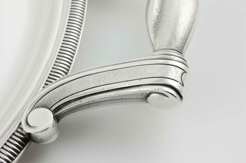 An extra large oval silver-plated tray with reeded border detail and two outer scroll handles on a plain background. View XII