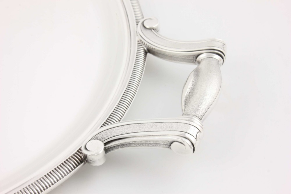 An extra large oval silver-plated tray with reeded border detail and two outer scroll handles on a plain background. View XIII