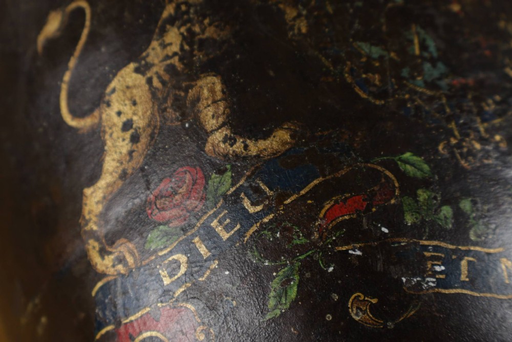 A dark brown Georgian leather fire bucket featuring a heavy strap handle, brass studs around the base, and a painted royal coat of arms with a lion and unicorn. View IX