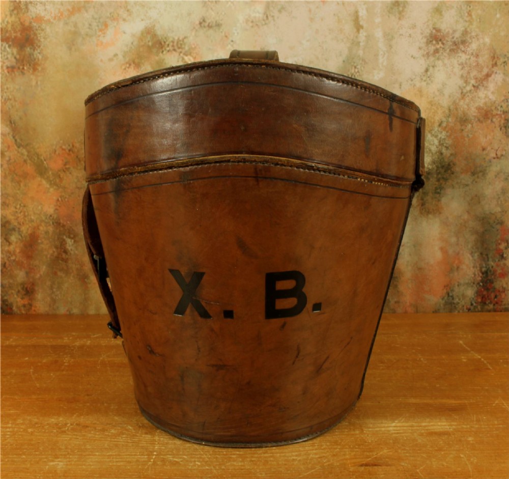 An open Victorian brown leather hat case featuring a padded bright red quilted silk lining and removable hat support collars. View V