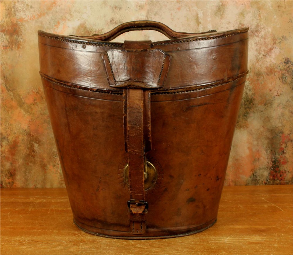 An open Victorian brown leather hat case featuring a padded bright red quilted silk lining and removable hat support collars. View VI