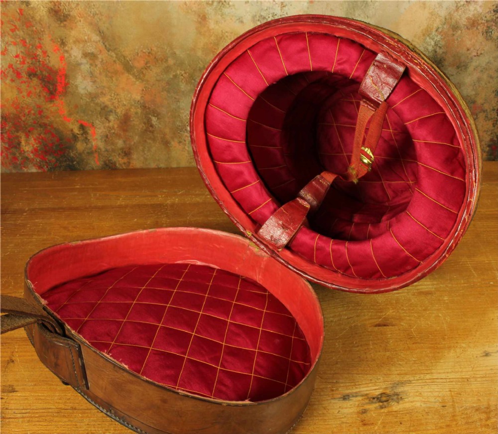 An open Victorian brown leather hat case featuring a padded bright red quilted silk lining and removable hat support collars. View VIII