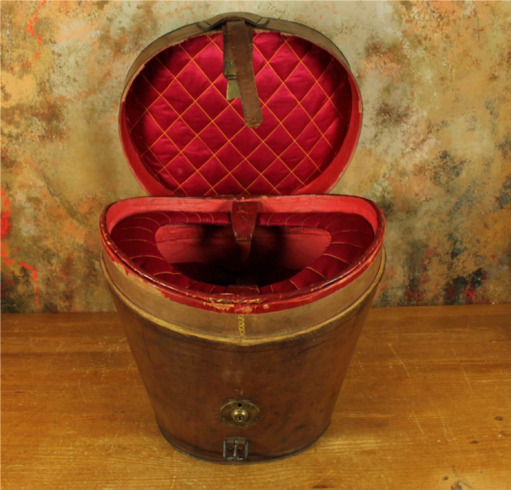 An open Victorian brown leather hat case featuring a padded bright red quilted silk lining and removable hat support collars. View XI