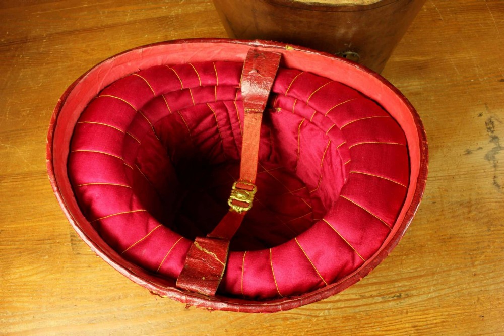 An open Victorian brown leather hat case featuring a padded bright red quilted silk lining and removable hat support collars. View XIII