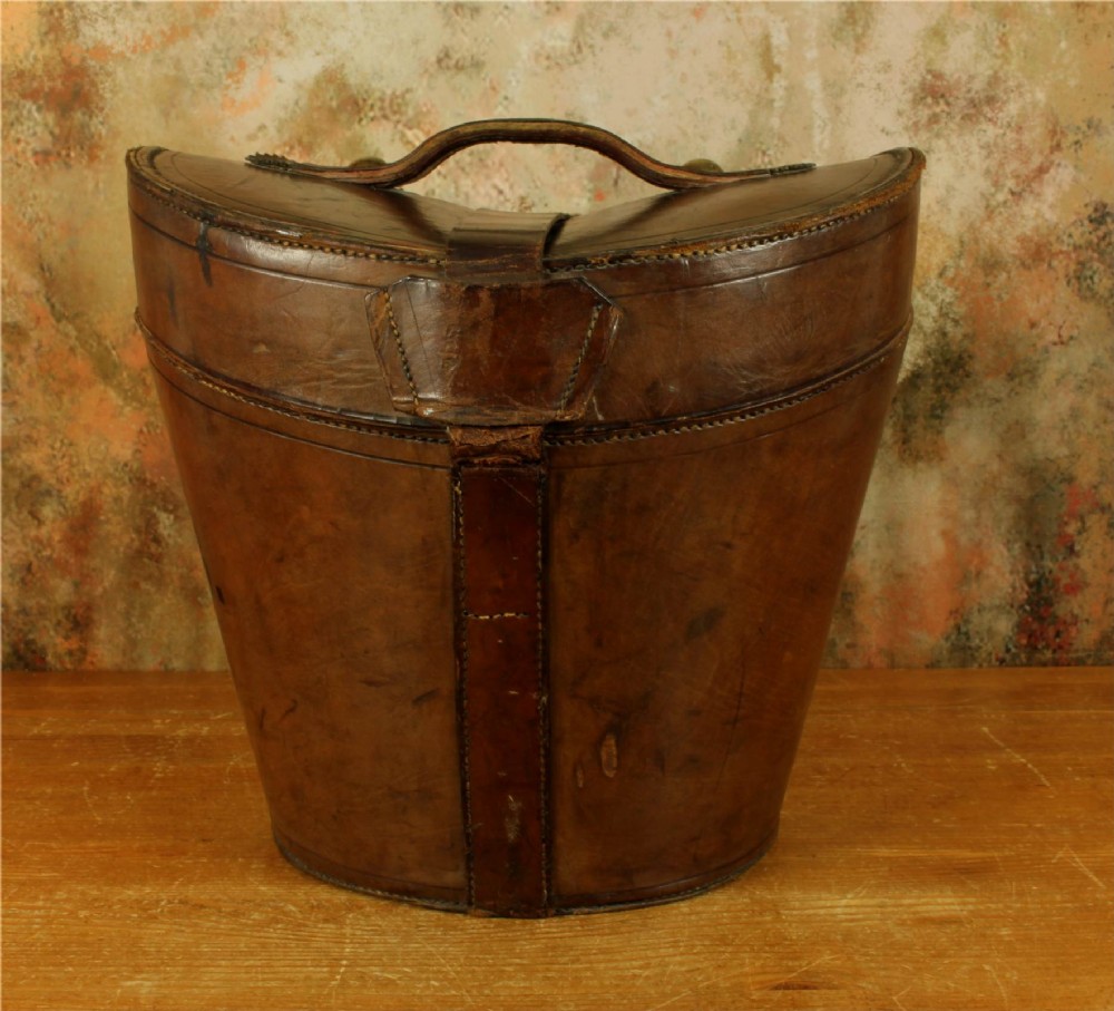 An open Victorian brown leather hat case featuring a padded bright red quilted silk lining and removable hat support collars. View XV