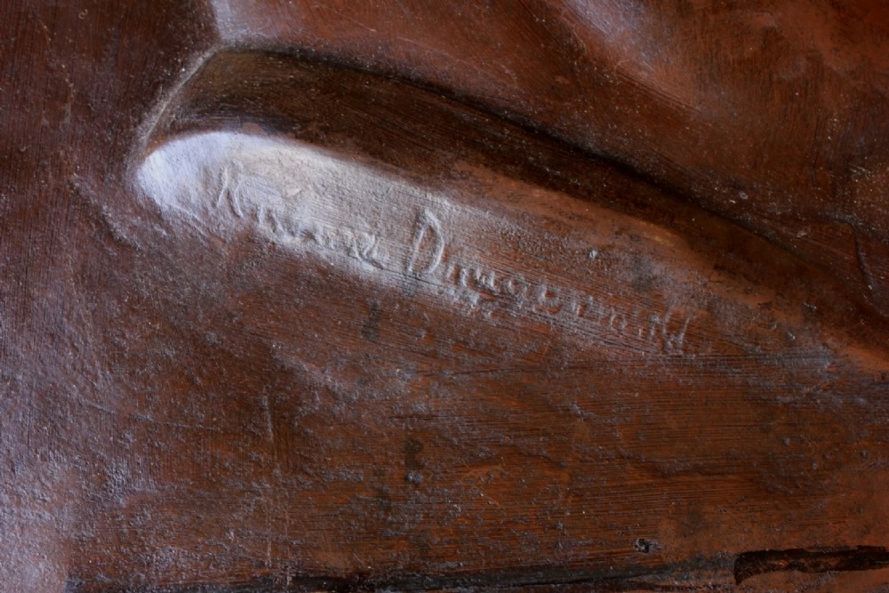 A dark brown bronze rectangular plaque featuring a low-relief profile portrait of a man facing right. View IV
