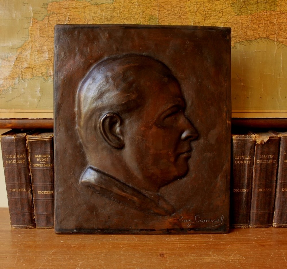 A dark brown bronze rectangular plaque featuring a low-relief profile portrait of a man facing right. View VI