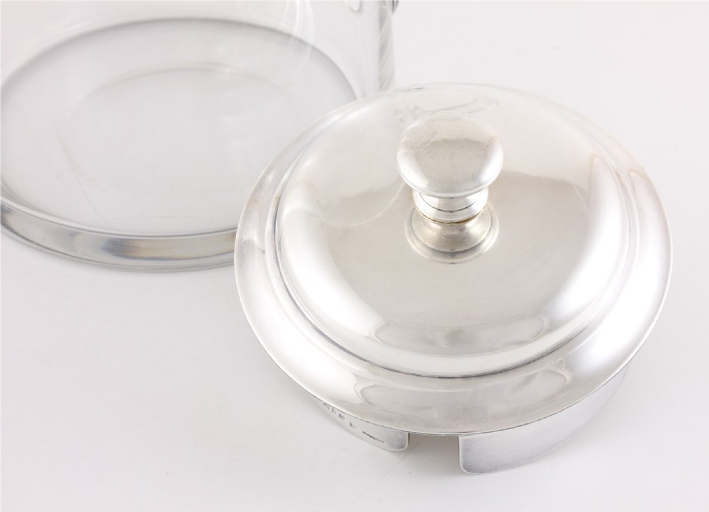 A clear glass water jug with a silver-plated hinged lid, integrated strainer spout, and curved glass handle. View XI