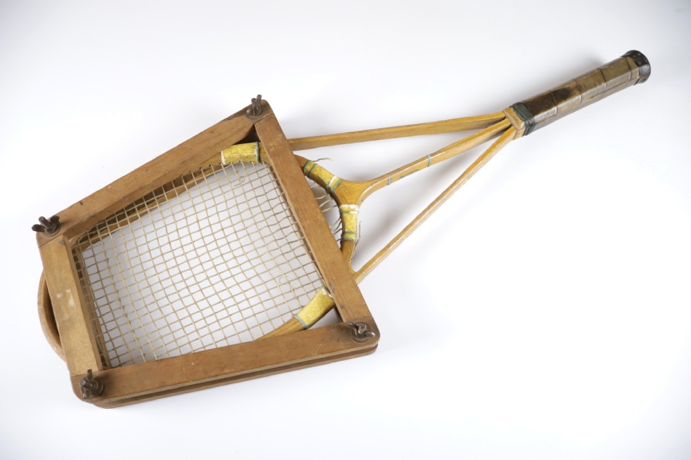 A 1930s Hazells Streamline wooden tennis racket with a triple shaft throat shown alongside a square wooden racket press. View III