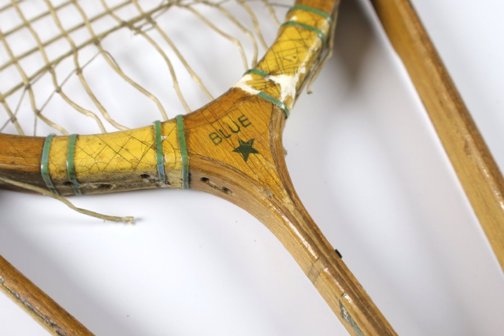 A 1930s Hazells Streamline wooden tennis racket with a triple shaft throat shown alongside a square wooden racket press. View IV
