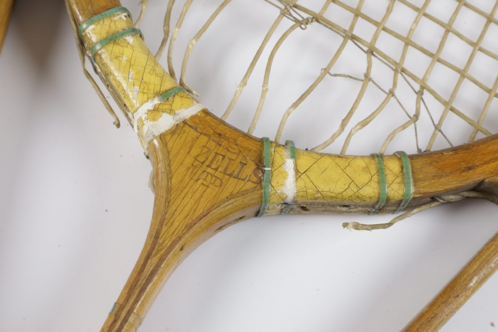 A 1930s Hazells Streamline wooden tennis racket with a triple shaft throat shown alongside a square wooden racket press. View V
