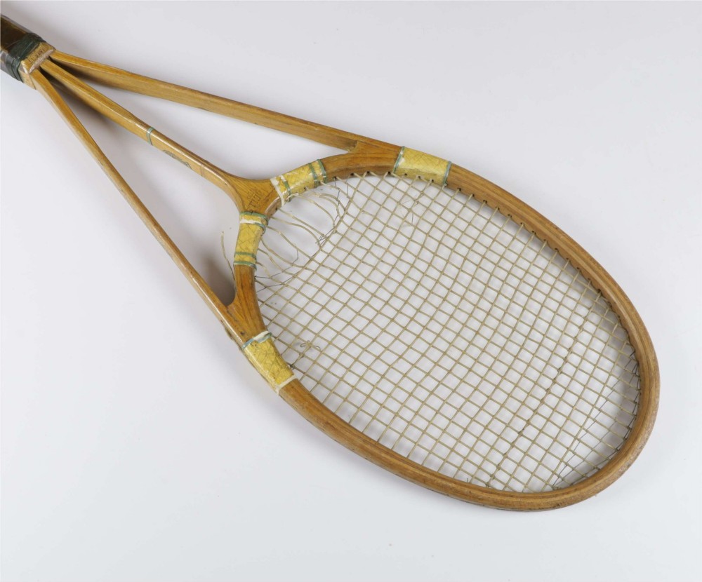 A 1930s Hazells Streamline wooden tennis racket with a triple shaft throat shown alongside a square wooden racket press. View VII
