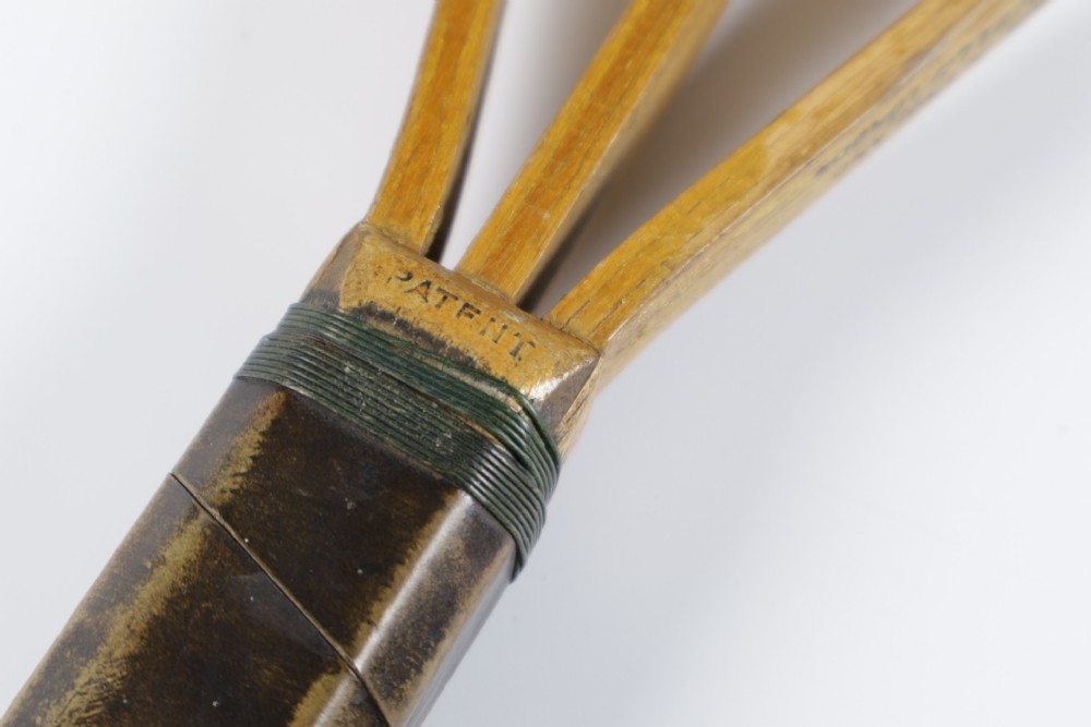 A 1930s Hazells Streamline wooden tennis racket with a triple shaft throat shown alongside a square wooden racket press. View XIII
