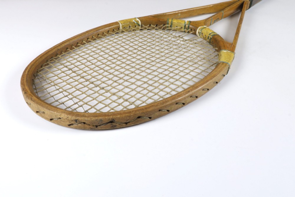 A 1930s Hazells Streamline wooden tennis racket with a triple shaft throat shown alongside a square wooden racket press. View XIV