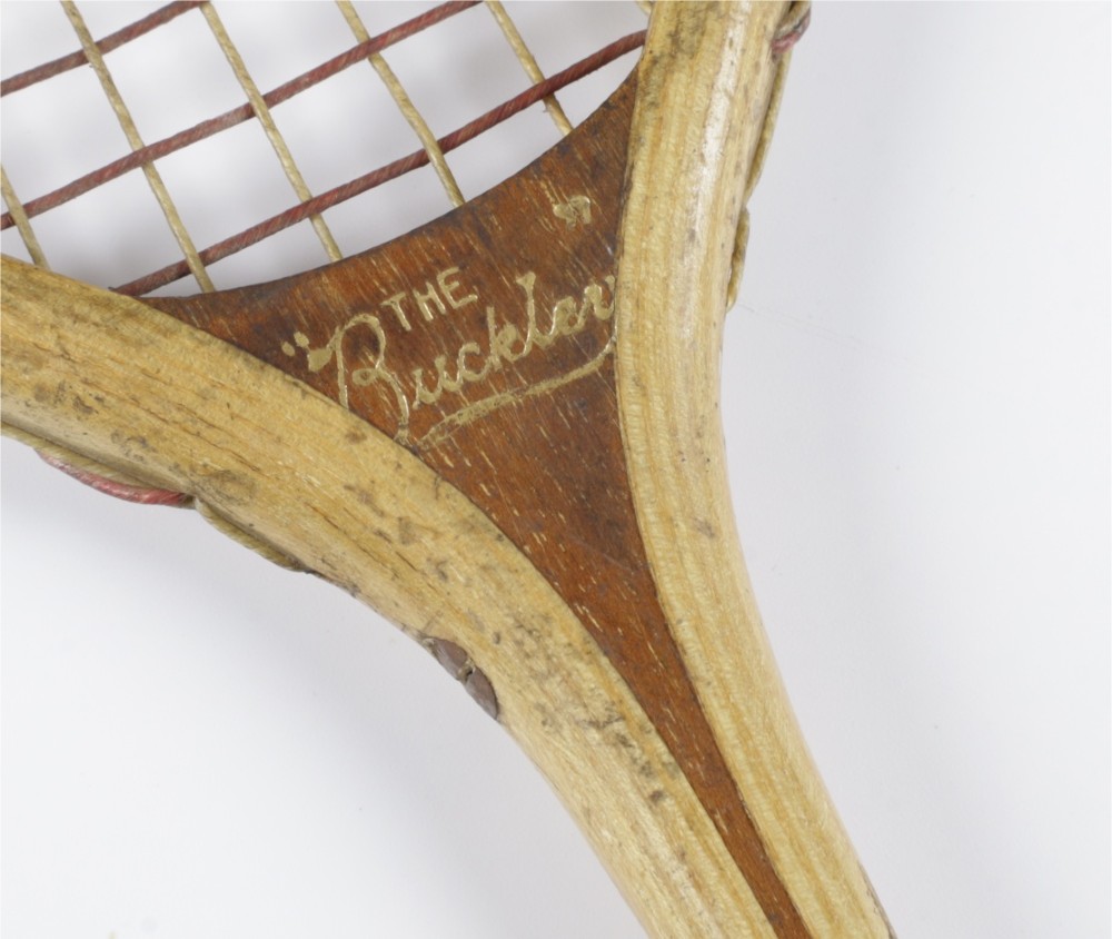 An antique Slazenger wooden badminton racket with a steam-bent frame, stringing, and a long wooden shaft. View IV