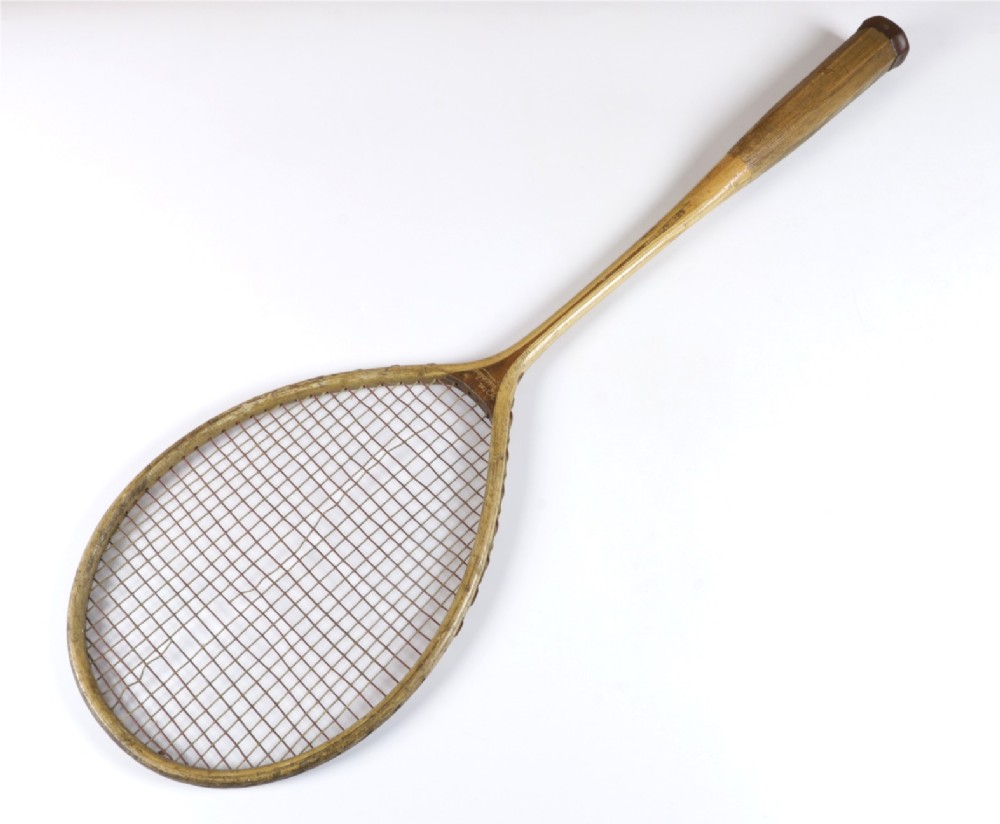 An antique Slazenger wooden badminton racket with a steam-bent frame, stringing, and a long wooden shaft. View V