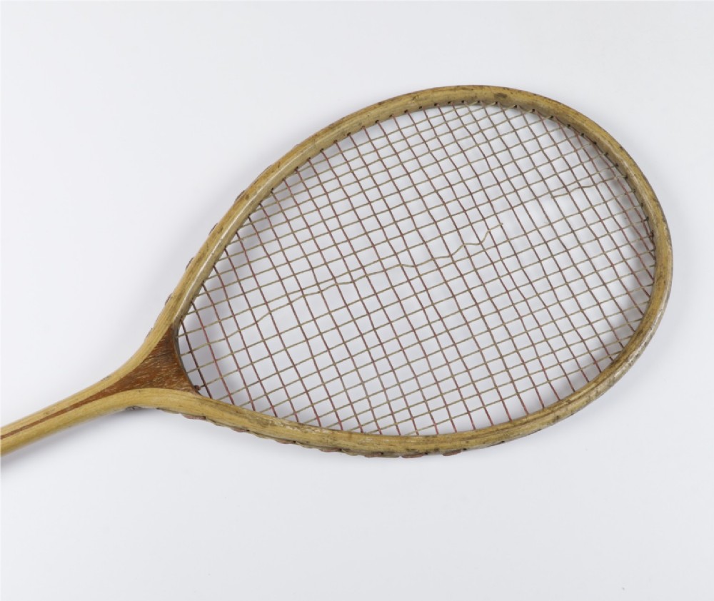 An antique Slazenger wooden badminton racket with a steam-bent frame, stringing, and a long wooden shaft. View VI