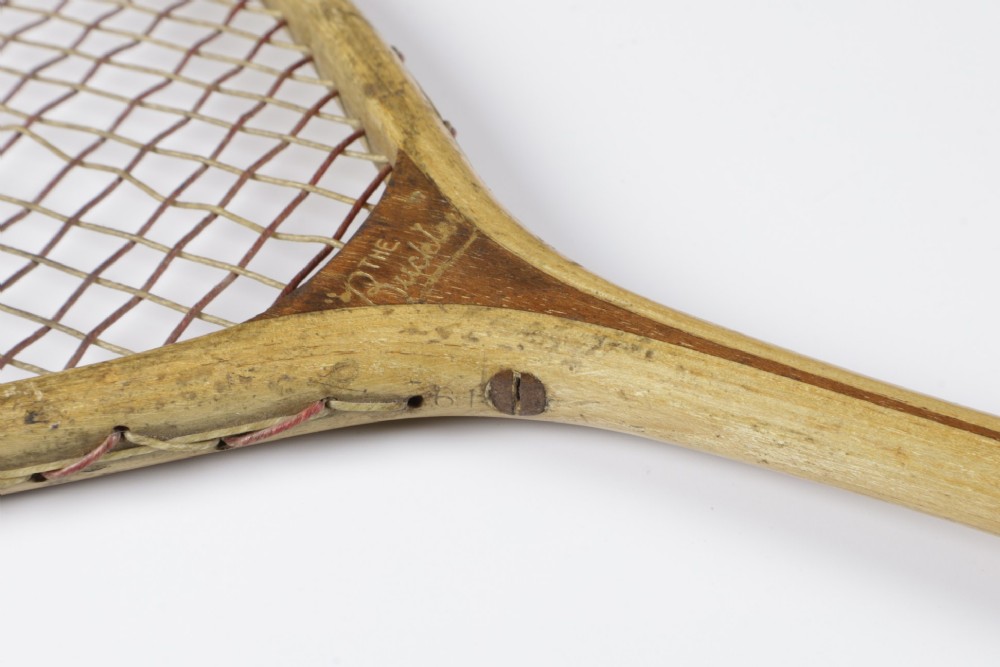 An antique Slazenger wooden badminton racket with a steam-bent frame, stringing, and a long wooden shaft. View IX