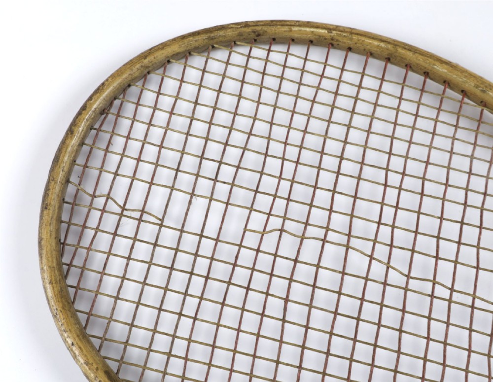 An antique Slazenger wooden badminton racket with a steam-bent frame, stringing, and a long wooden shaft. View XV