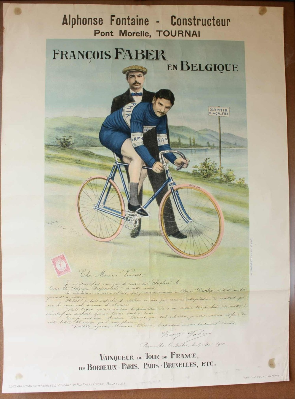 An early twentieth-century Belgian advertising poster depicting cyclist Francois Faber aboard a blue bicycle with French text and a landscape background.