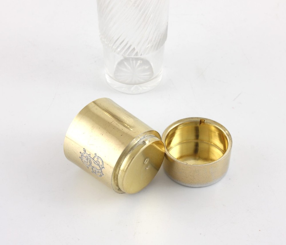 A cylindrical clear glass flask featuring spiral fluting, topped with a domed silver cap and a silver base bearing an engraved monogram. View III