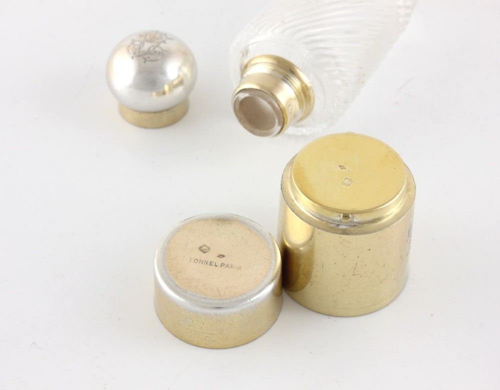 A cylindrical clear glass flask featuring spiral fluting, topped with a domed silver cap and a silver base bearing an engraved monogram. View VI
