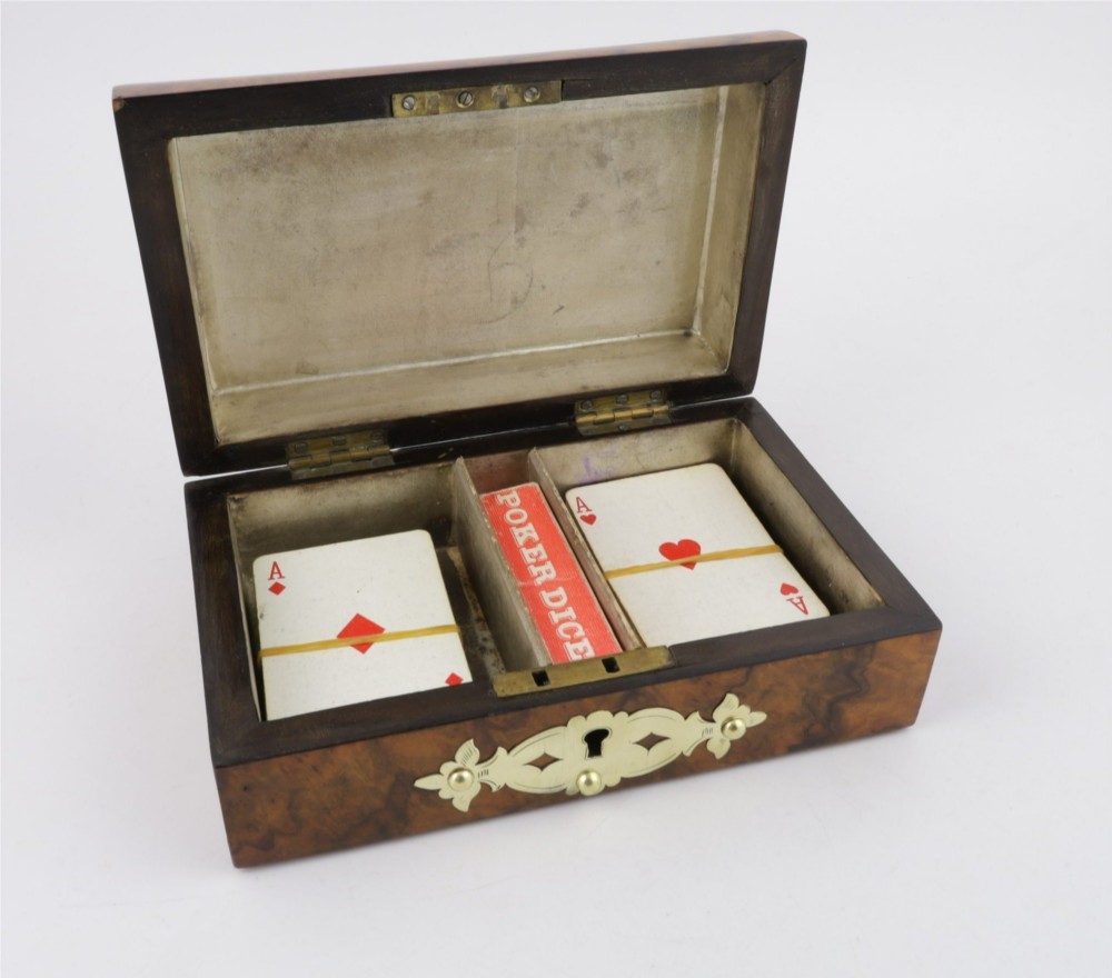 A domed burr walnut box featuring polished brass strapwork depicting three playing cards on the lid and a brass keyhole escutcheon on the front. View II