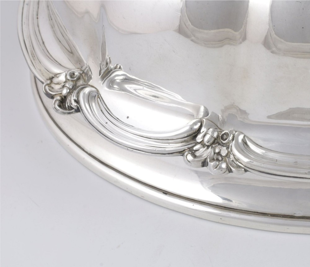 A Georgian Old Sheffield plate silver meat dome featuring a fluted body, an engraved heraldic coat of arms, and a cast handle adorned with vine leaves and grapes. View VII