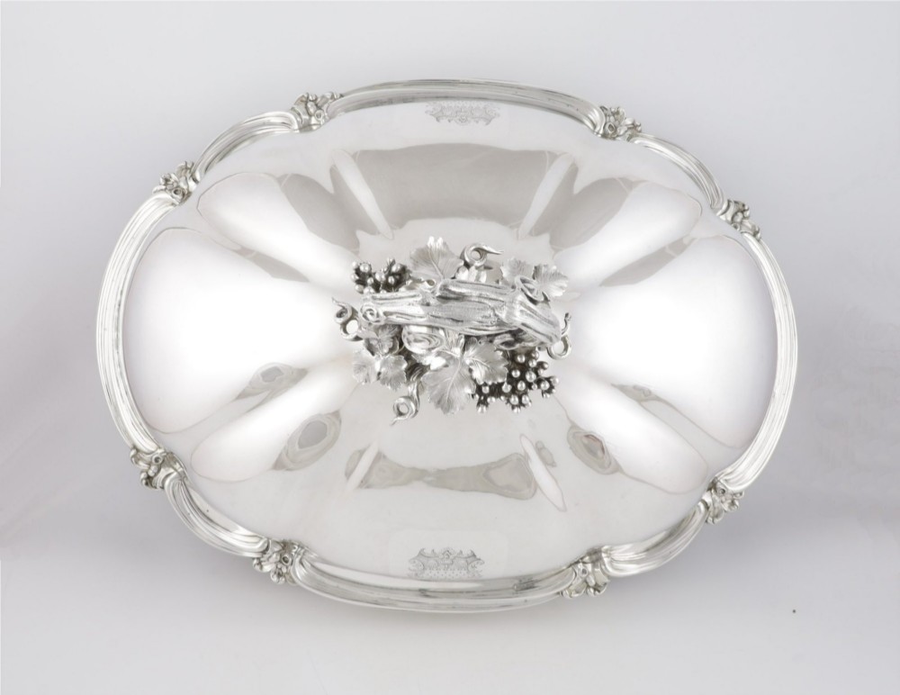 A Georgian Old Sheffield plate silver meat dome featuring a fluted body, an engraved heraldic coat of arms, and a cast handle adorned with vine leaves and grapes. View VIII