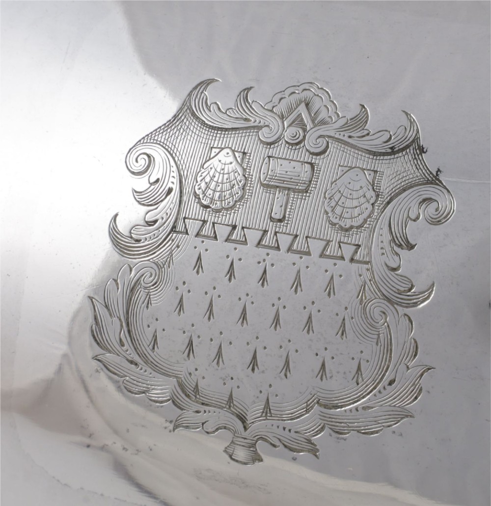 A Georgian Old Sheffield plate silver meat dome featuring a fluted body, an engraved heraldic coat of arms, and a cast handle adorned with vine leaves and grapes. View X