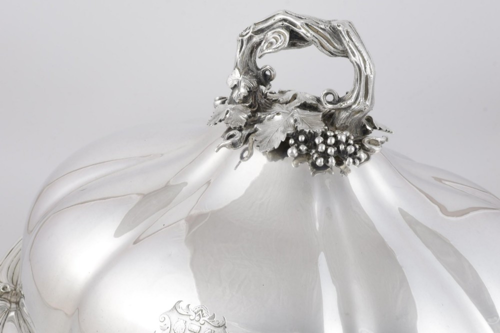 A Georgian Old Sheffield plate silver meat dome featuring a fluted body, an engraved heraldic coat of arms, and a cast handle adorned with vine leaves and grapes. View XIII