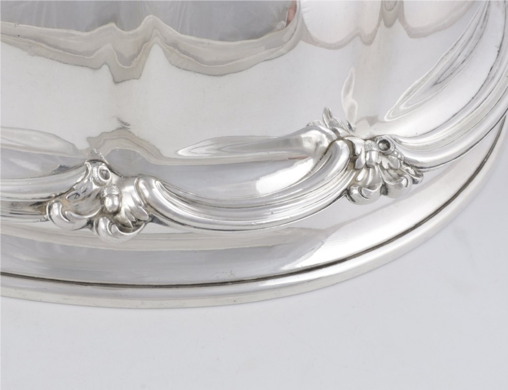 A Georgian Old Sheffield plate silver meat dome featuring a fluted body, an engraved heraldic coat of arms, and a cast handle adorned with vine leaves and grapes. View XIV