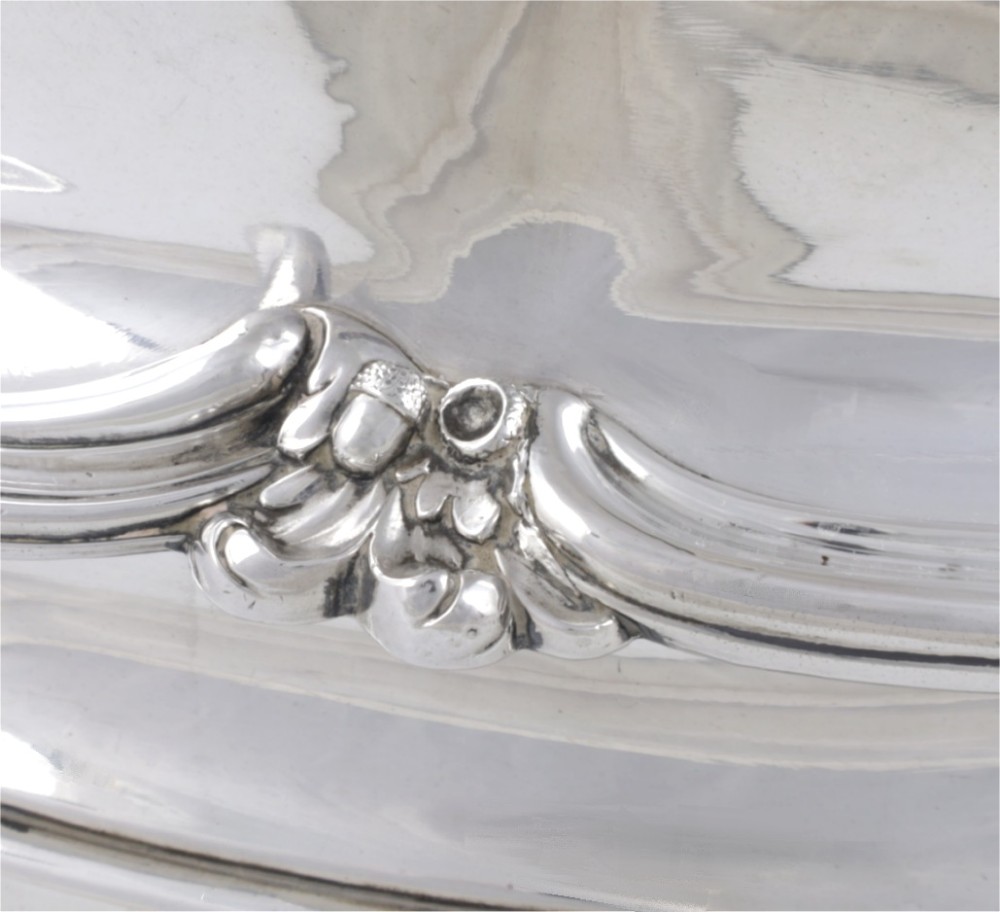 A Georgian Old Sheffield plate silver meat dome featuring a fluted body, an engraved heraldic coat of arms, and a cast handle adorned with vine leaves and grapes. View XV