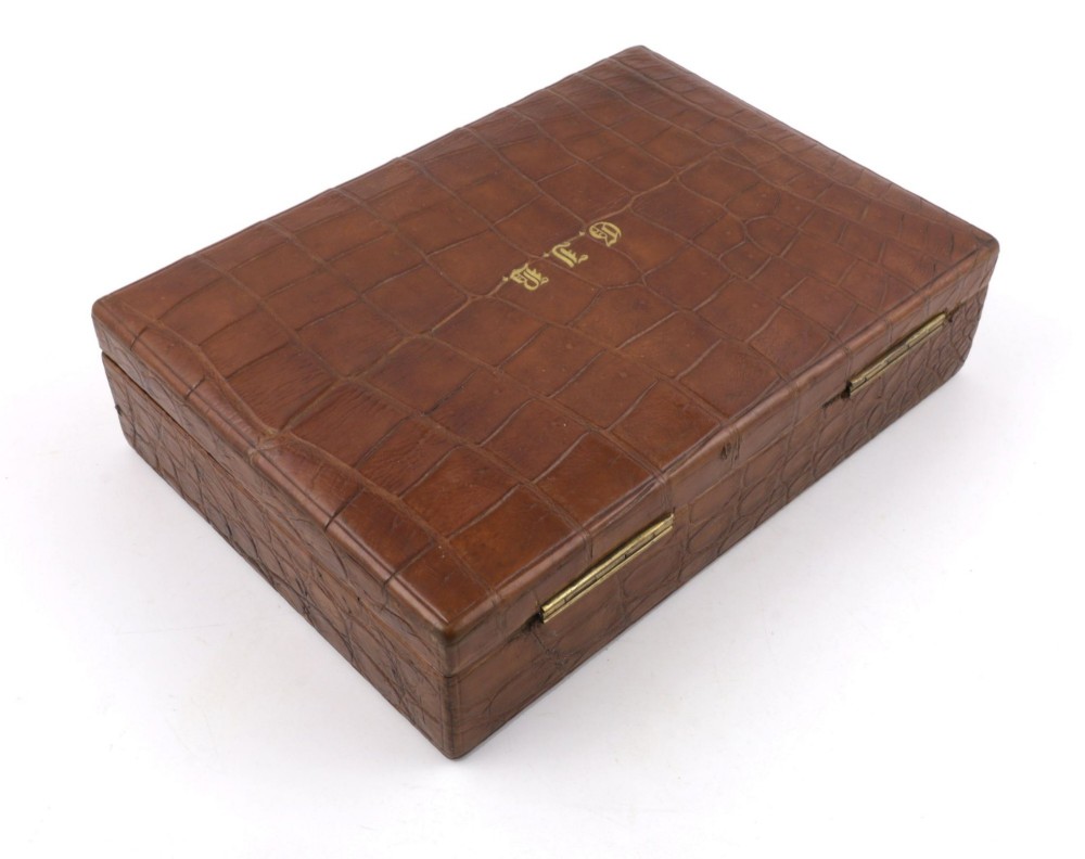 An open brown crocodile leather jewellery case featuring a green velvet lined interior with multiple compartments and brass lock hardware. View XIII