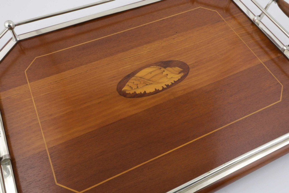 An octagonal brown wooden serving tray featuring a shell marquetry inlay and a polished silver-plated gallery rail. View IV