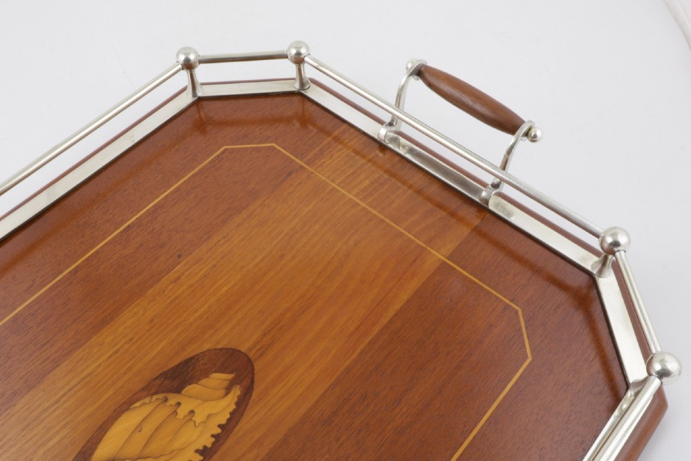 An octagonal brown wooden serving tray featuring a shell marquetry inlay and a polished silver-plated gallery rail. View VII
