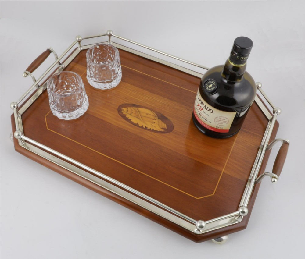 An octagonal brown wooden serving tray featuring a shell marquetry inlay and a polished silver-plated gallery rail. View X