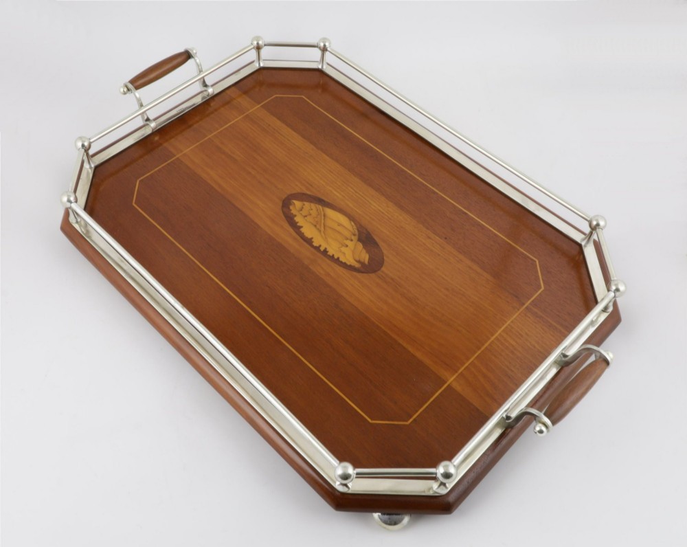 An octagonal brown wooden serving tray featuring a shell marquetry inlay and a polished silver-plated gallery rail. View XI