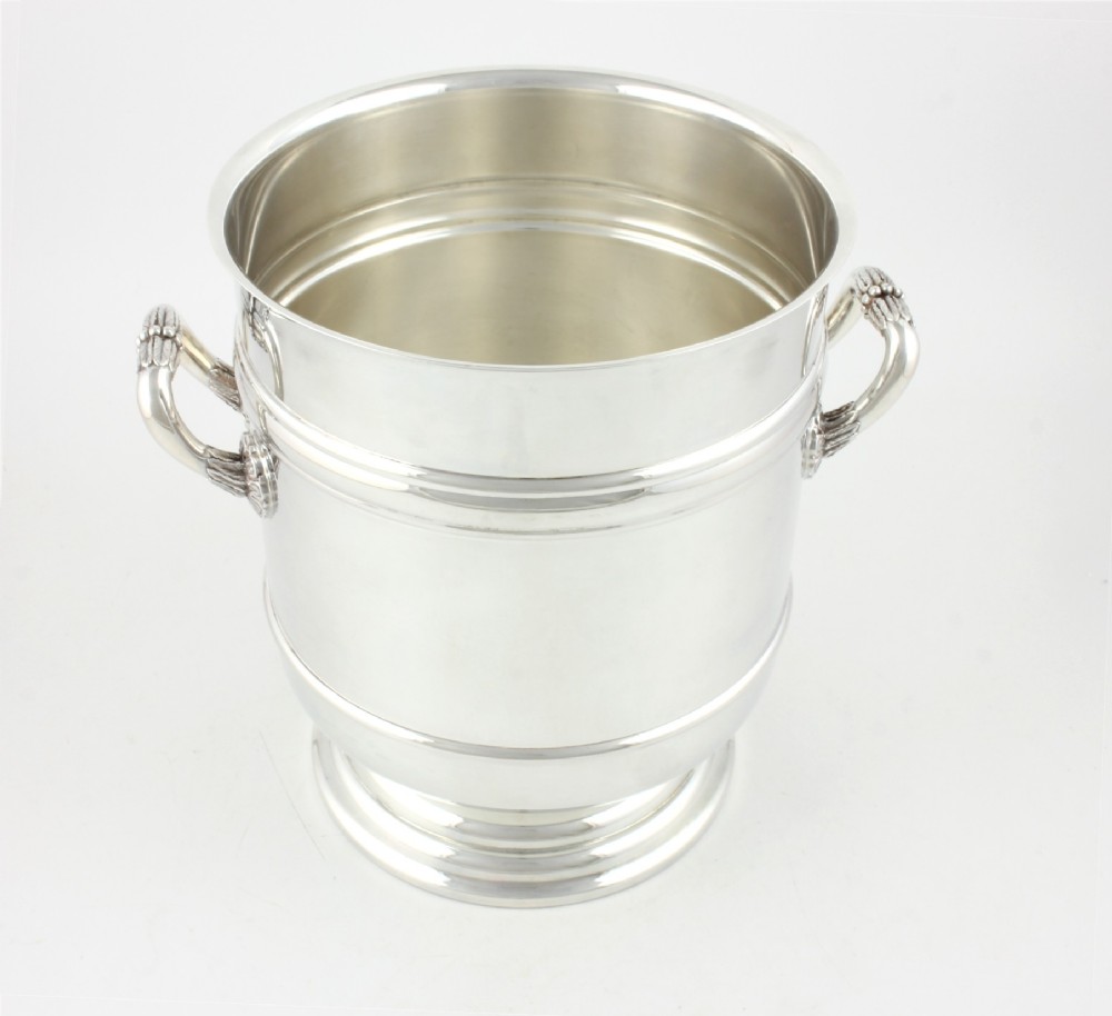 A polished silver-plated champagne cooler featuring side handles with leaf detailing and a stepped pedestal base. View V