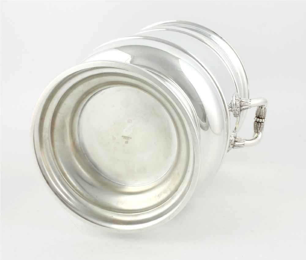 A polished silver-plated champagne cooler featuring side handles with leaf detailing and a stepped pedestal base. View IX