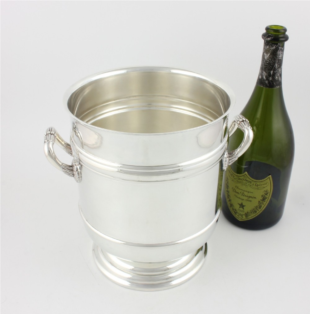 A polished silver-plated champagne cooler featuring side handles with leaf detailing and a stepped pedestal base. View XI