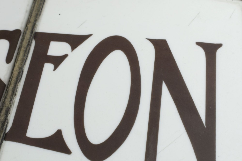 An Edwardian leaded glass window panel set in a dark wooden frame with white glass panes featuring black lettering that reads DENTAL SURGEON. View XI