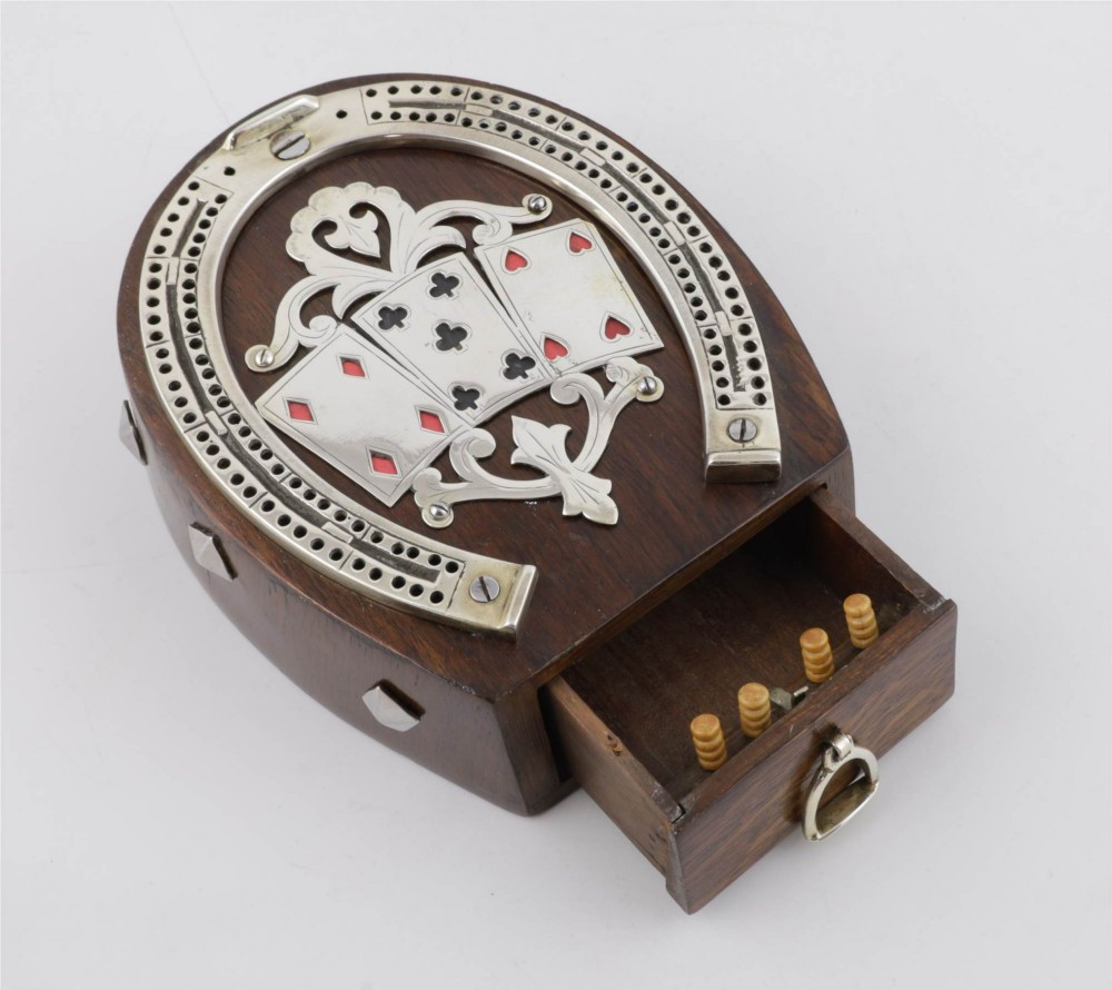 An antique horseshoe-shaped dark oak games box featuring silver metal scrollwork, playing card motifs, and an integrated cribbage scoring track. View II