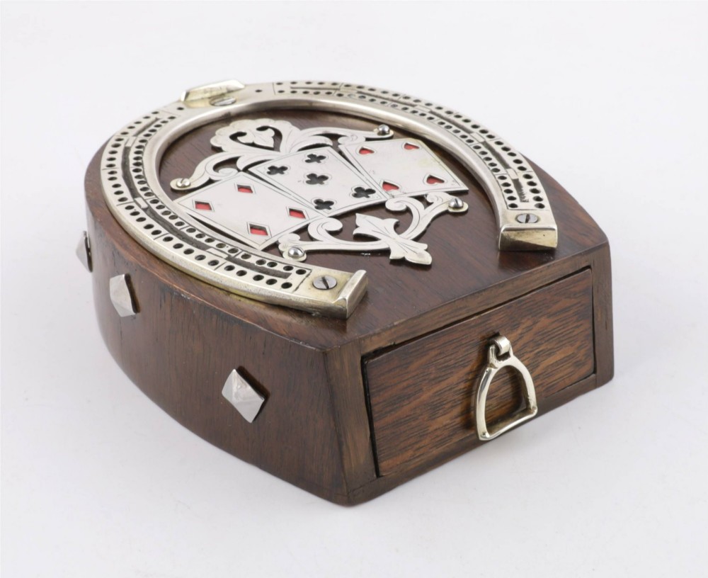 An antique horseshoe-shaped dark oak games box featuring silver metal scrollwork, playing card motifs, and an integrated cribbage scoring track. View V